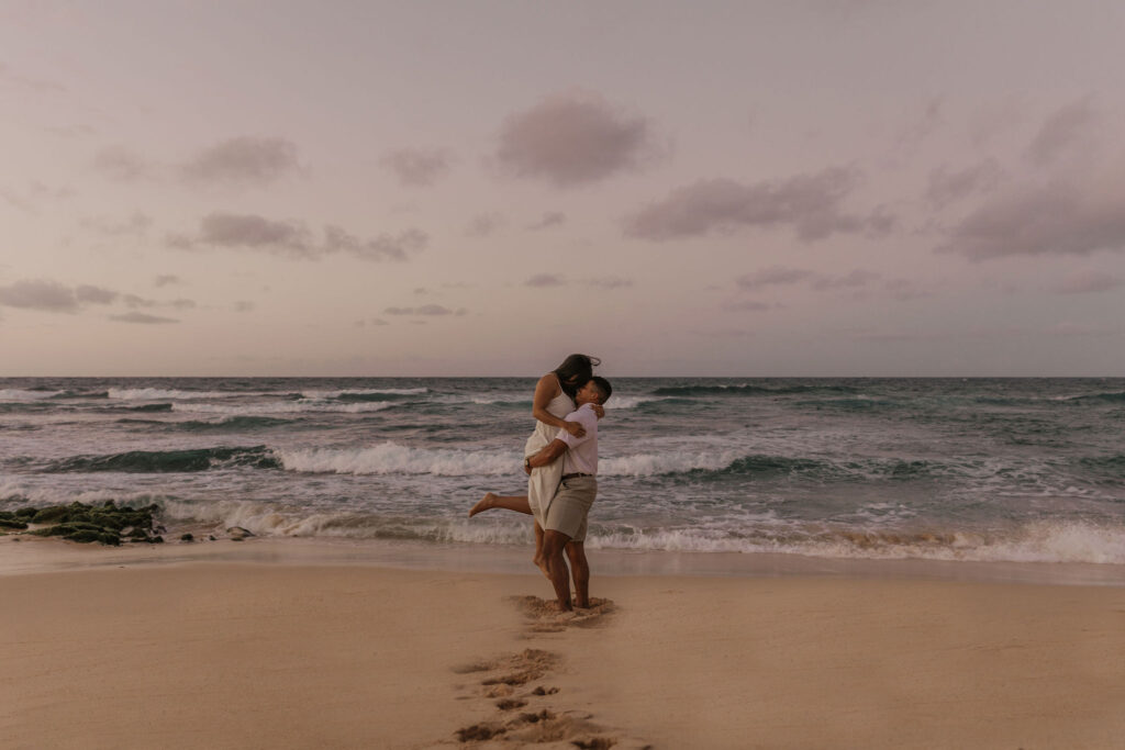 couple dancing between lava rock at Oahu Hawaii beach