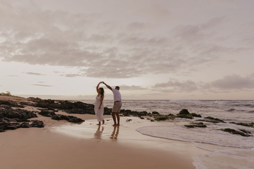 couple dancing between lava rock at Oahu Hawaii beach