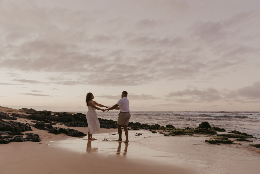 couple dancing between lava rock at Oahu Hawaii beach