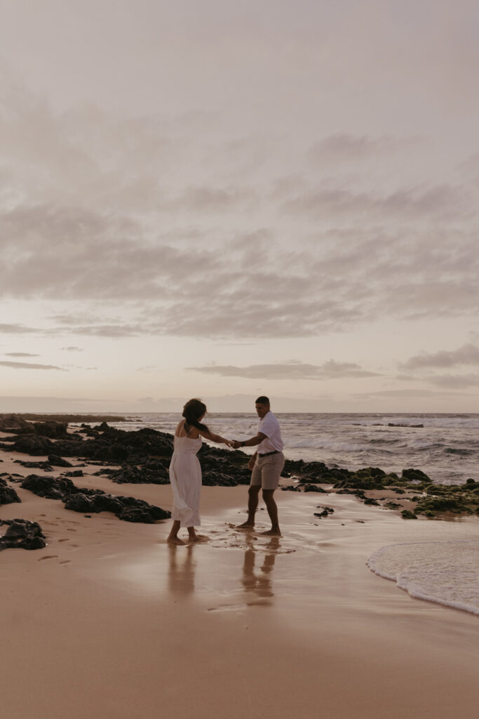 couple dancing between lava rock at Oahu Hawaii beach