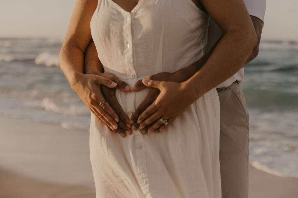 couple's pregnancy announcement on the beach at sunrise in Oahu, Hawaii