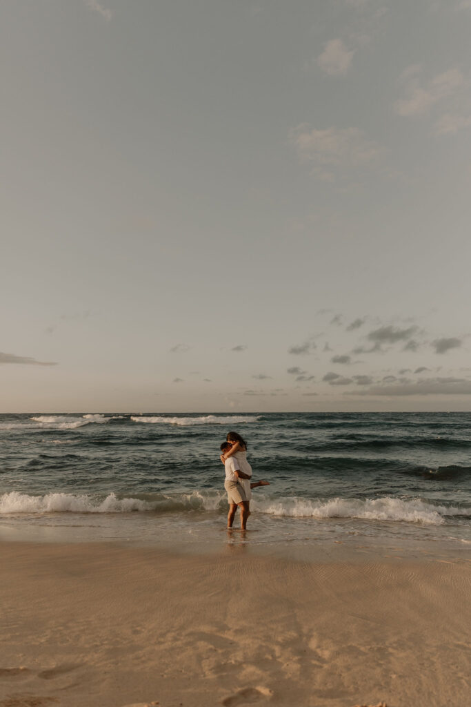 couple on the beach at sunrise in Oahu, Hawaii