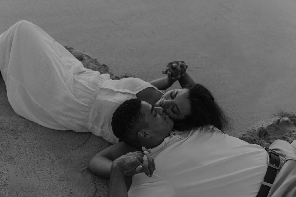 Couple kissing in the sand of a beach in Oahu, Hawaii