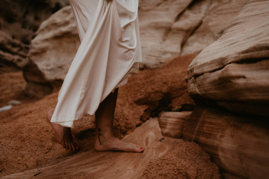 Bride hiking barefoot in a wedding dress in the desert sand of Nevada