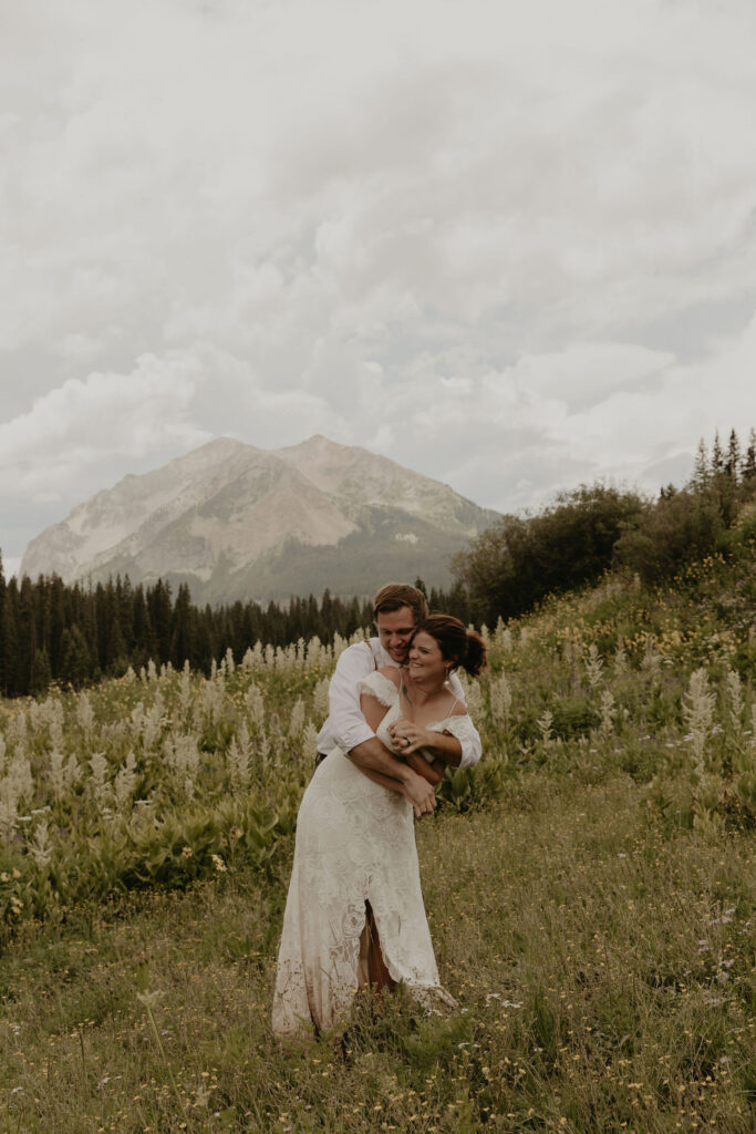 Couple hugging in a wildflower fields at the base of Mount Crested Butte, Colorado