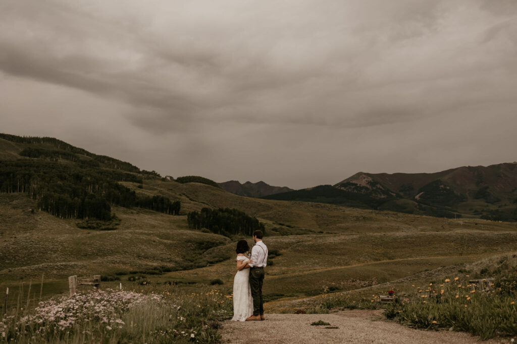 Wide shot of couple looking out towards the Rocky Mountains
