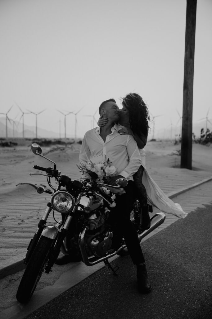 Black and white of couple on motorcycle kissing