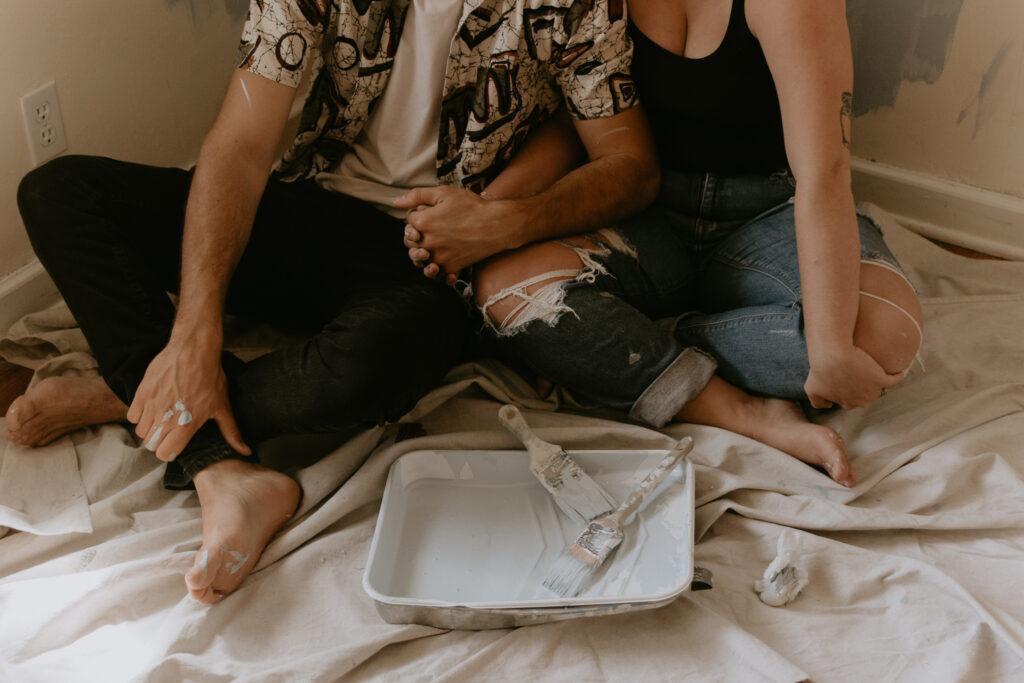 Close up of couple holding hands with a paint tray in front of them for a creative photoshoot