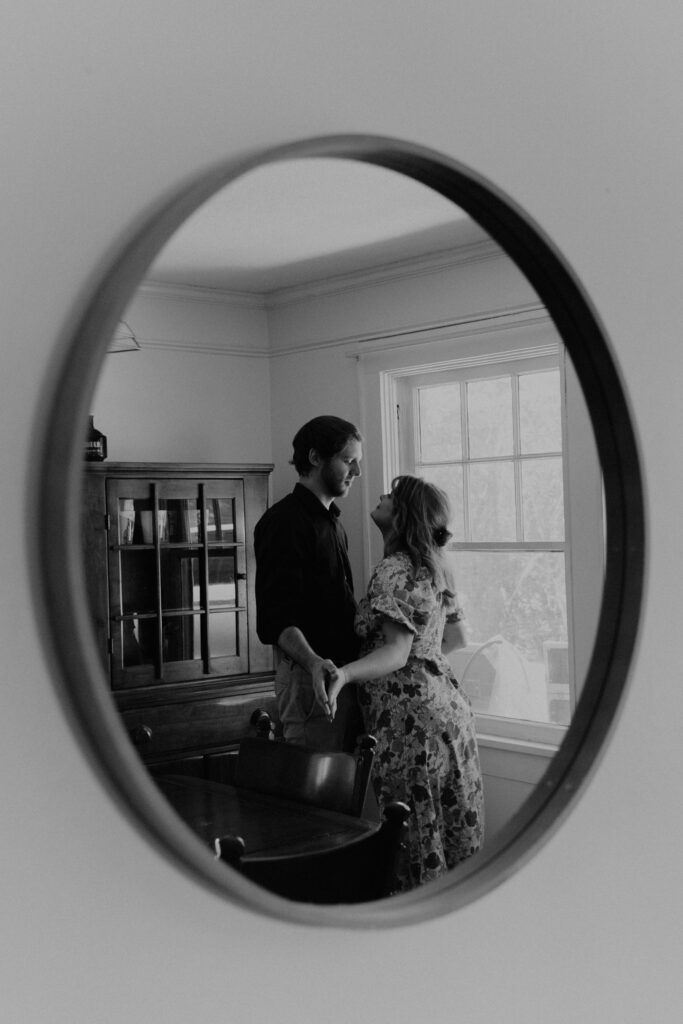 Reflection through a mirror of couple dancing in black and white
