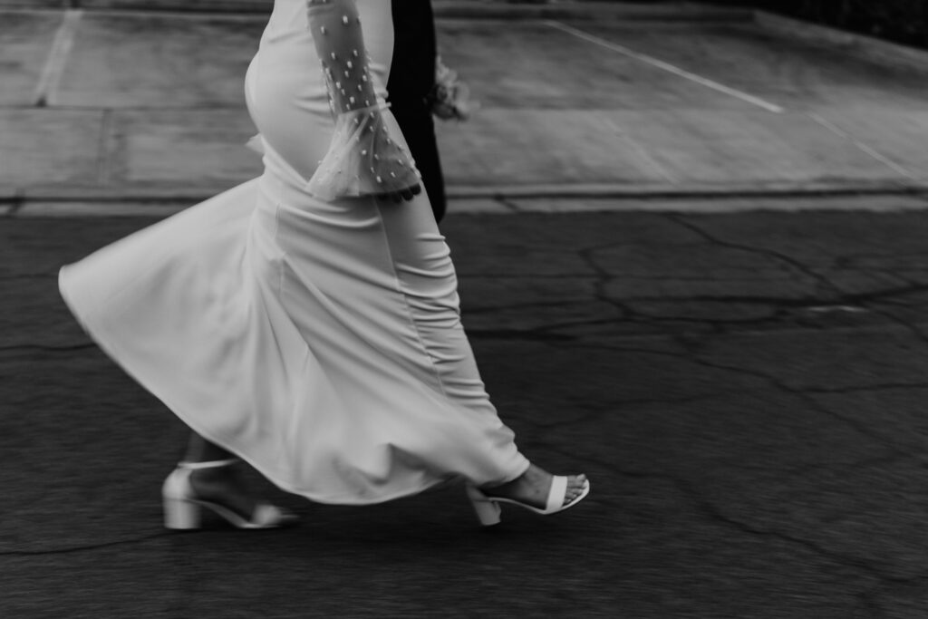Motion blur of bride walking down the street in her wedding dress