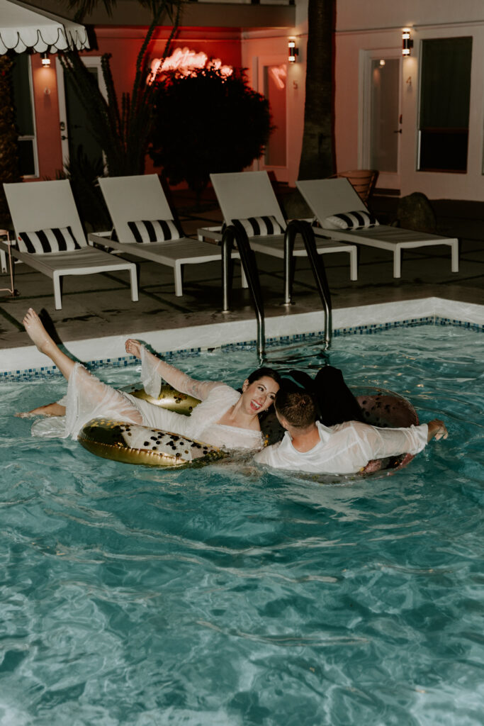 Couple jumping into their hotel pool in wedding clothes