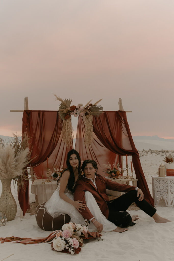 Couple sitting in front of a Moroccan picnic design for their elopement dinner
